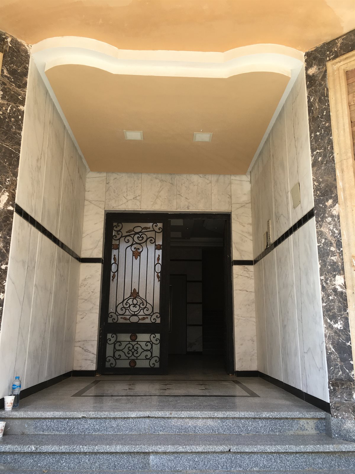 البنفسج — مدخل بتكسية رخام وباب حديد مشغول