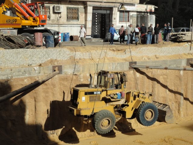 Sheriff Plaza handling equipment — crane lowering loader into the pit